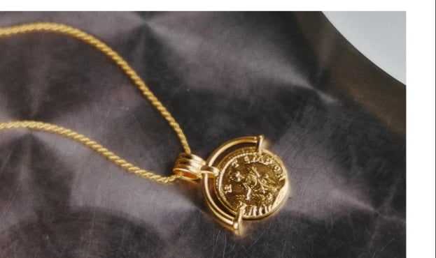 A pendant resting on dark fabric
