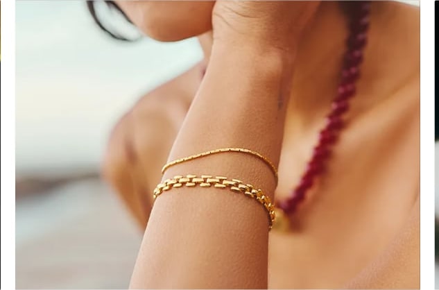 Gold bracelet styled with red beads